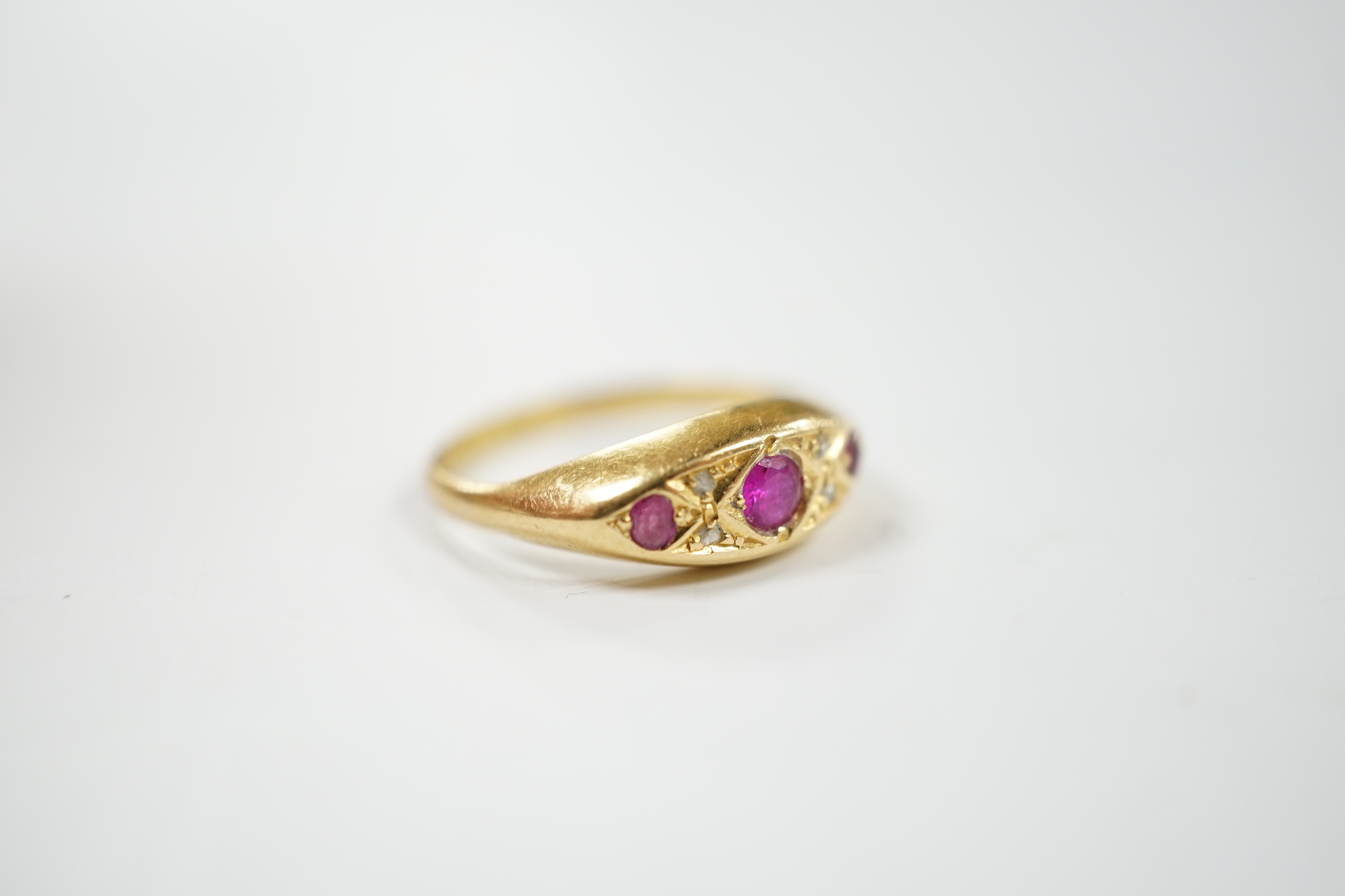 A George V 18ct gold, three stone ruby and four stone diamond chip set ring, size K, gross weight 2.4 grams.